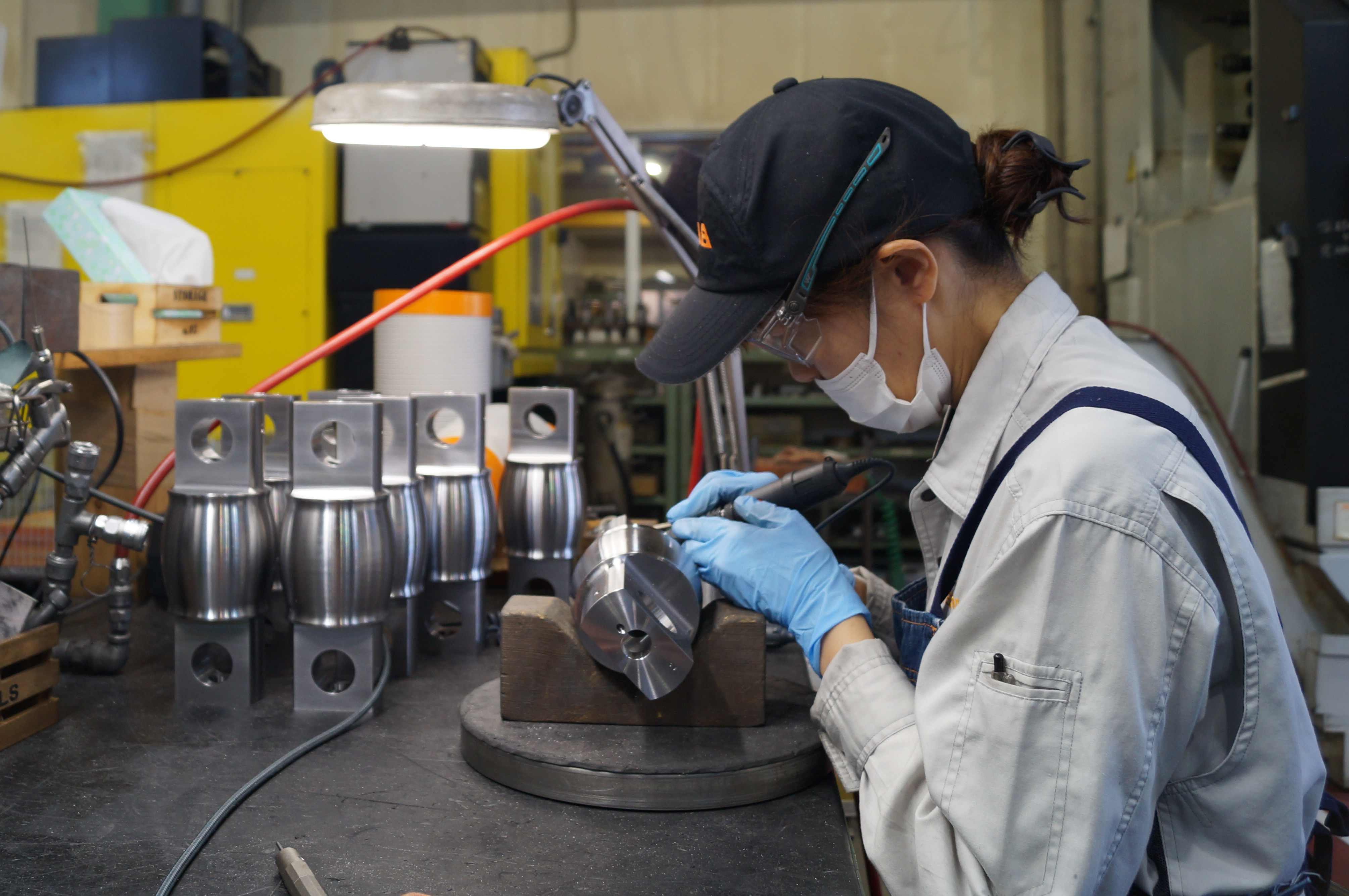 バリ取りをする機械加工の女性従業員１ 機械加工のTEKNIA名古屋工場