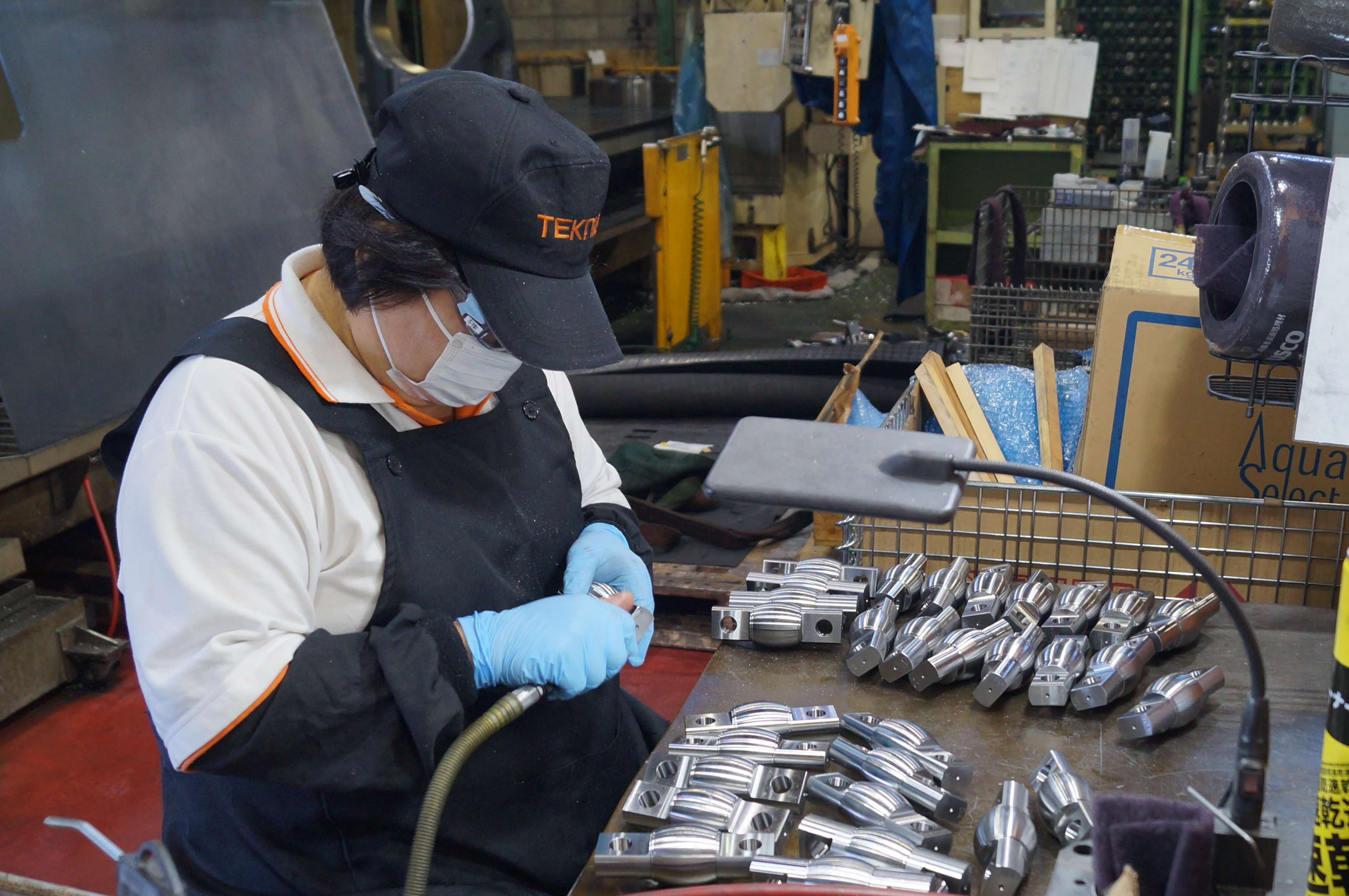 バリ取りをする機械加工の女性従業員２ 機械加工のTEKNIA名古屋工場